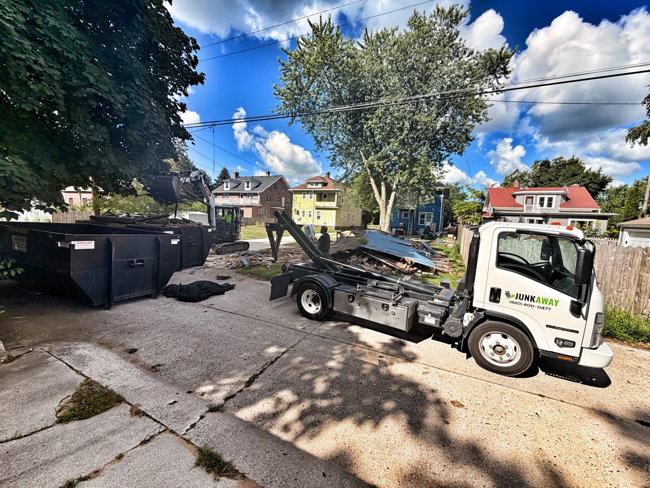 JunkAway truck and containers beside demolition debris at the garage project